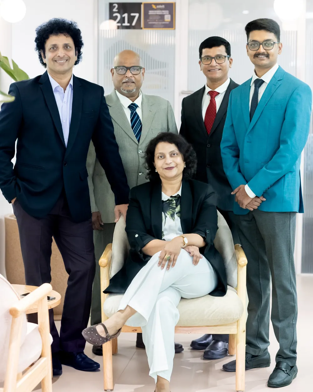 The LadderStep team standing together in the office, with Mahua Gorthi seated in front.